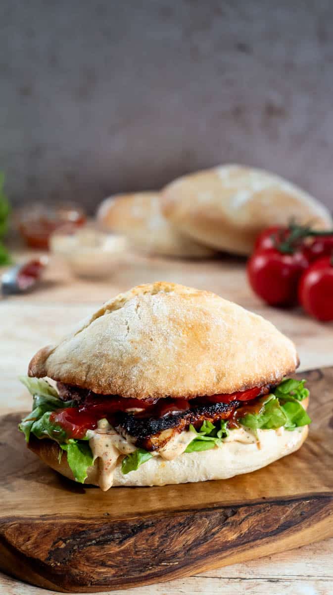 A vertical image showing the side view of the Nando's burger with all the ingredients inside,