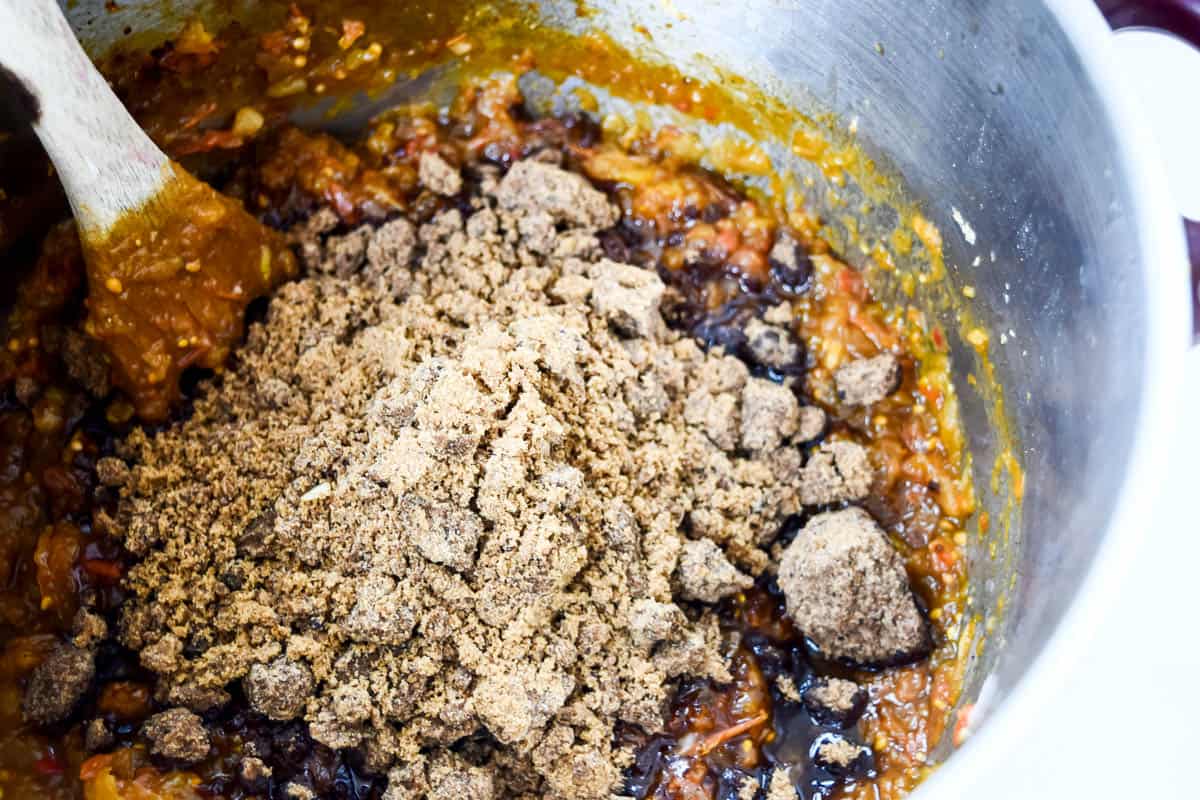 Dark brown sugar in a pile, having been added to the chutney mixture.