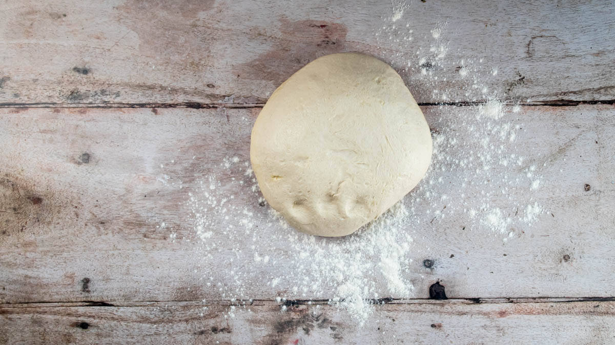 The rested bread dough on a floured surface.