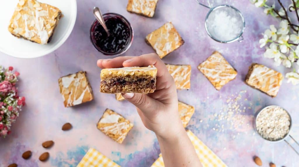 A hand is holding a flapjack up to the camera to show the layers.