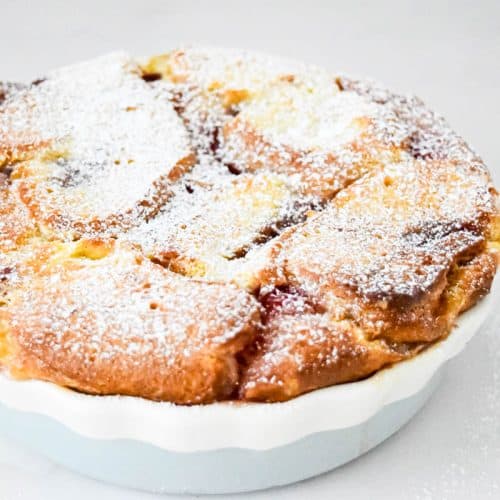 A dish containing the baked doughnut pudding.