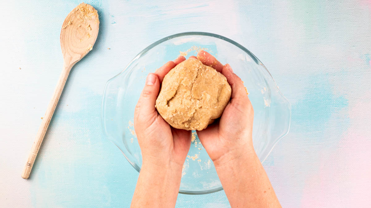 Two hands are cupping the finished dough ball.