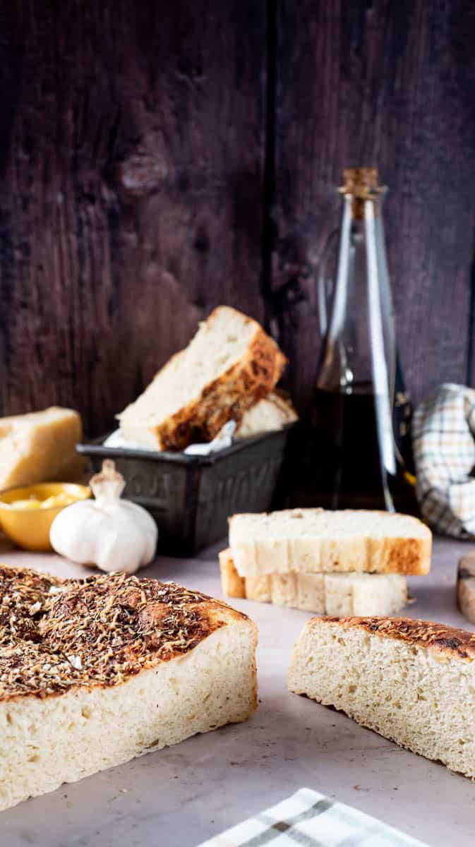A vertical image that shows the front of the focaccia at an angle sliced open.