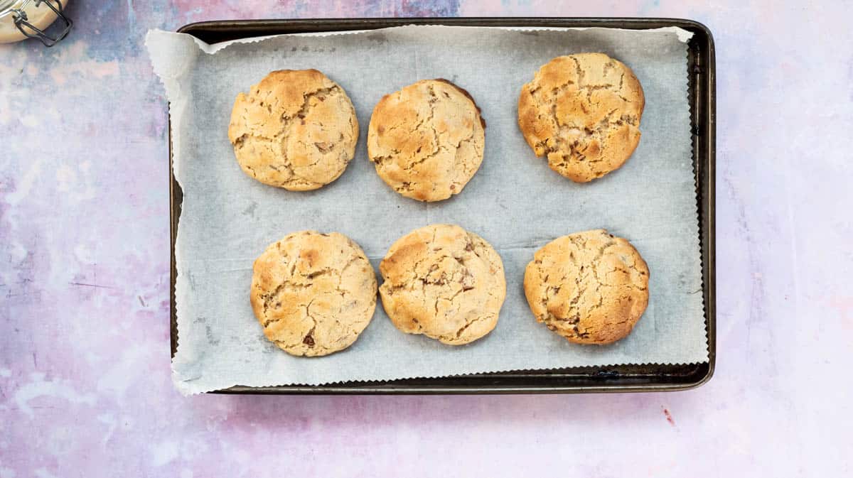 Baked Kinder Bueno cookies on a lined baking tray.