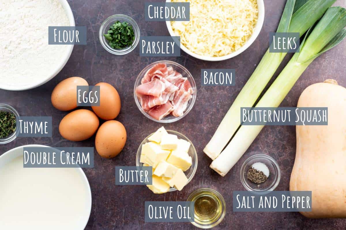 A labelled photo of all the ingredients needed to make a leek and squash quiche.