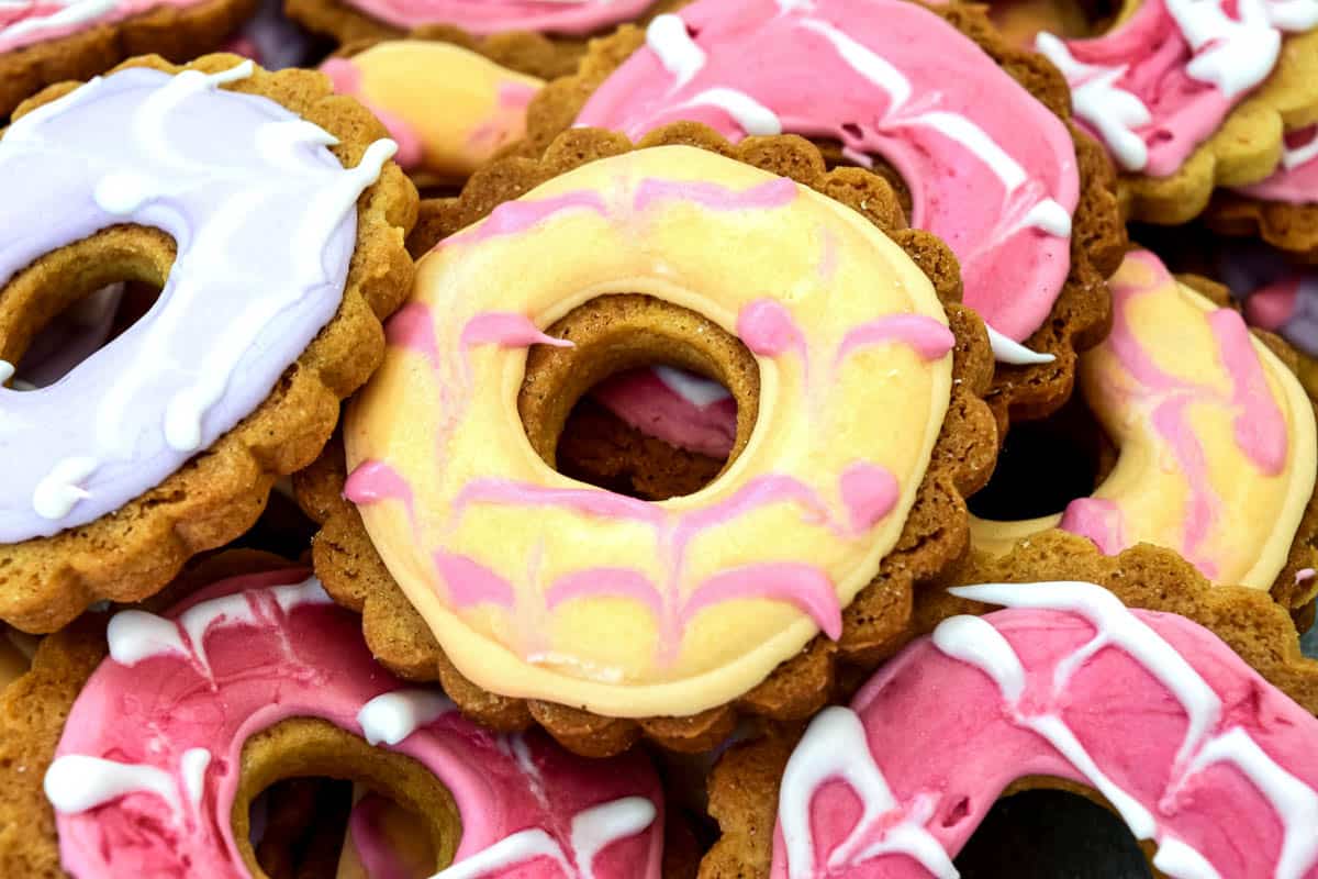 A close up of a pile of party rings biscuits of all different colours.