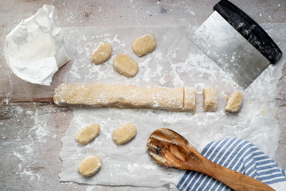 An overhead view of the dough roll with some of it having been portioned into cookie balls using a dough divider.