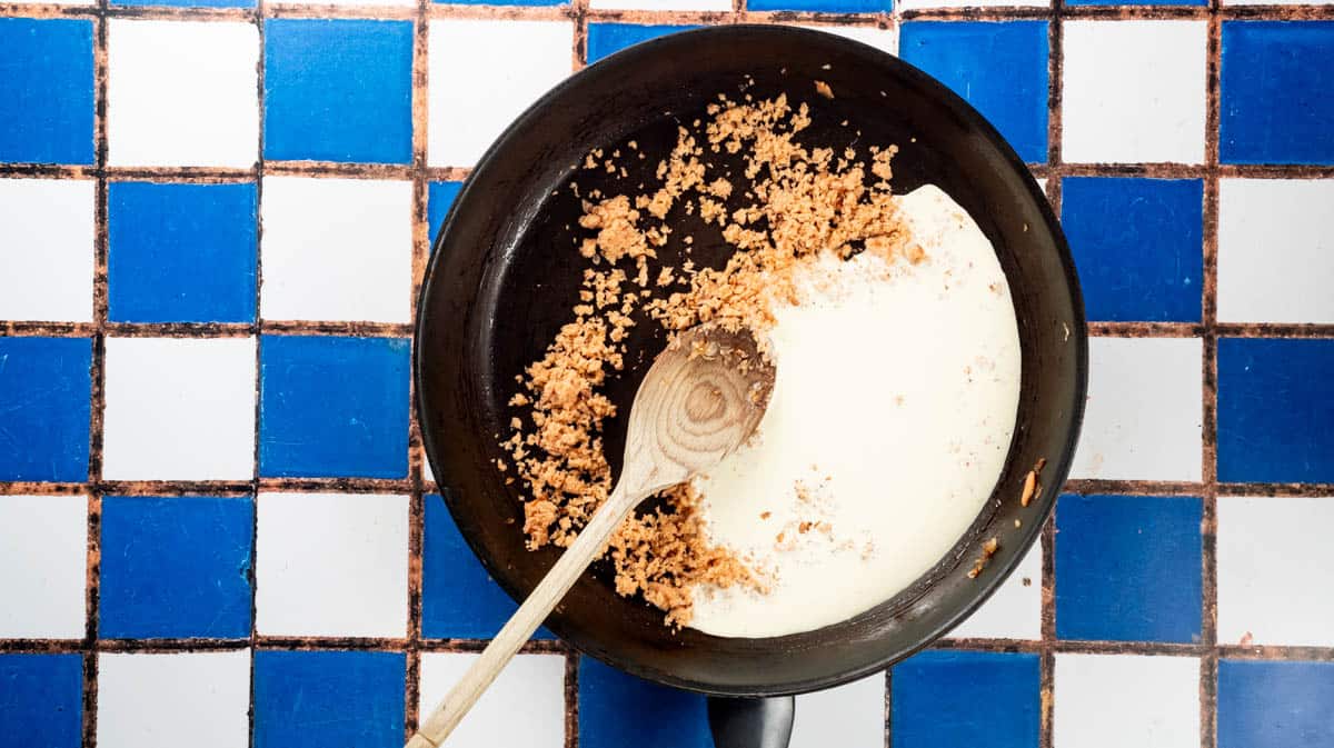 A frying pan filled with blended smoked salmon and cream before being mixed together.