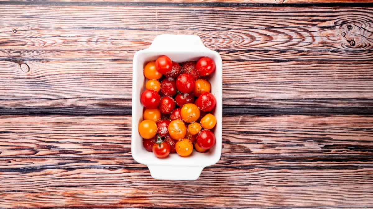 A white bowl filled with cherry tomatoes.