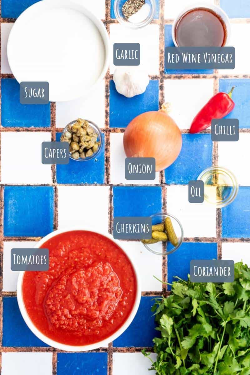 A labelled photo with all the ingredients needed to make tomato burger relish.