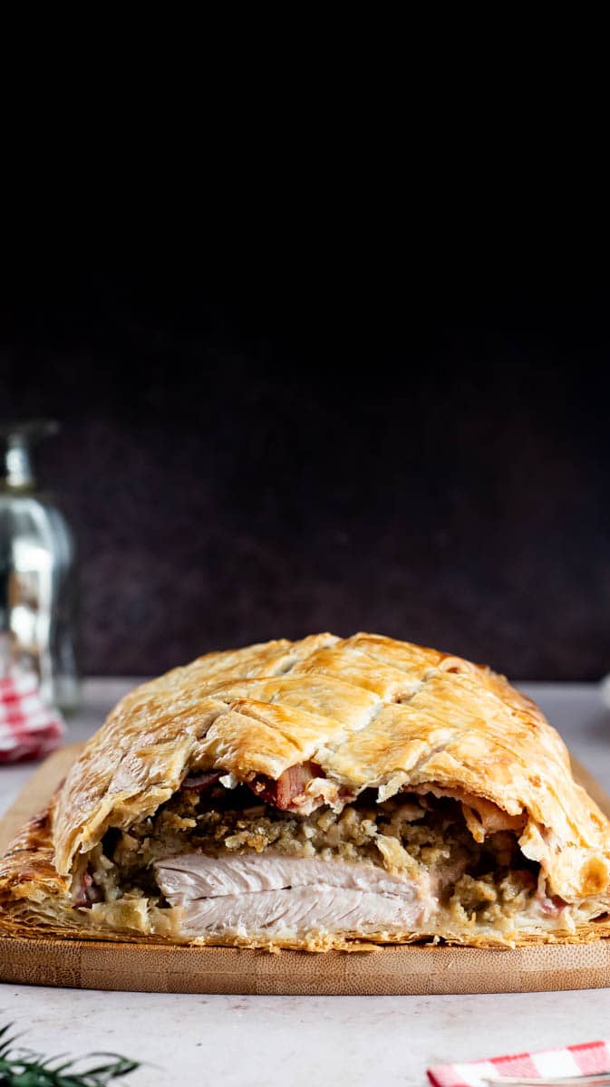 A photo showing a sliced Turkey En Croute from the front to show the filling and layers.